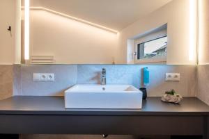 ein Badezimmer mit einem weißen Waschbecken und einem Spiegel in der Unterkunft Luisl Hof - Apartment Pomum in Girlan + 24 Fotos