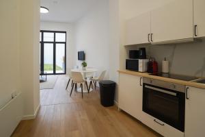 ブリュッセルにあるAppartment Vaillance 2のキッチン(白いキャビネット、ダイニングルーム付きのテーブル付) +9枚の写真