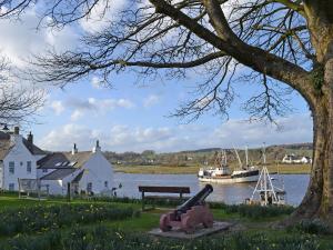 a bench next to a body of water with a boat at Home Farm in Dunragit +18 photos