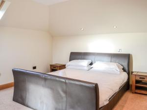 DunragitHome Farm的一张带皮革床头板的床