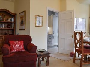 a living room with a red chair and a table at Causey Pike in Keswick