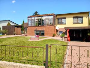 a house with a fence in front of a yard at Ferienwohnung Am Recknitzhang in Carlewitz