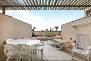 a patio with a white table and chairs on a patio at Casa Médano 3 By Médano Rentals in El Médano