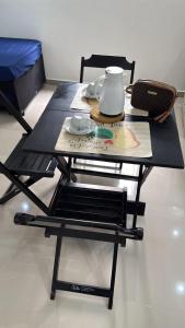 een zwarte tafel en stoel met daarop een theepot bij Apê da divisa in São Vicente