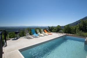 a group of chairs sitting next to a swimming pool at La Villa du Mas Lachamp in Gravières