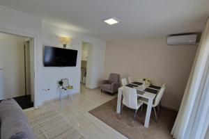 a living room with a table and chairs and a television at Seaview Studio Apartmani Sleeps 2 - WiFi & Tv in Crikvenica