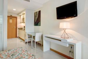 Schlafzimmer mit einem Schreibtisch und einem TV an der Wand in der Unterkunft Dfm Happy Days F - Funchal in Funchal