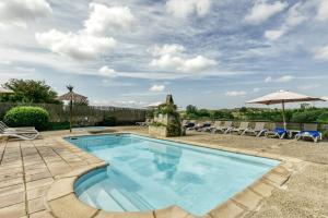 a swimming pool with chairs and umbrellas on a patio at El Mirador Rural de Can Gat Vell in Llampaies