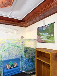 a room with a table and a painting on the wall at Novita Homestay in Bunaken