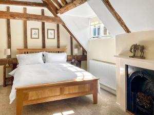 カンタベリーにあるThe Yeomans Cottage, Eastbridge Hospitalのベッドと暖炉のある寝室