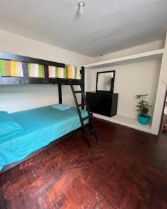 een slaapkamer met een stapelbed en een spiegel bij Lanihous in Huanchaco