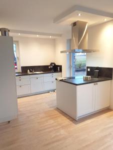 eine Küche mit weißen Schränken und einer Arbeitsplatte in der Unterkunft Ferienhaus Treibholz in Hof Barendorf