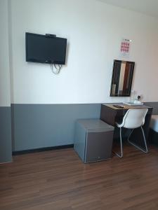 a room with a desk and a tv on a wall at SO Hotel in George Town +13 photos