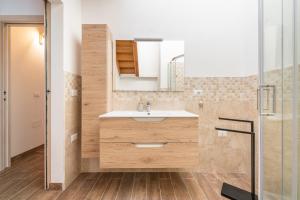 une salle de bain avec un lavabo et une douche dans l'établissement Casa Giovanna, à San Giovanni Suergiu 18 autres photos