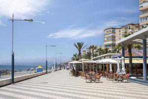 トロクス・コスタにあるBeachfront Bungalowのビーチの遊歩道(椅子、パラソル付)
