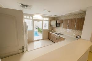 a kitchen with wooden cabinets and a large window at درة العروس فيلا الأحلام d in Jeddah