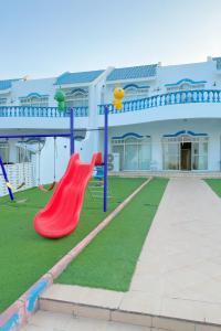 a playground in front of a building with a red slide at درة العروس فيلا الأحلام d in Jeddah