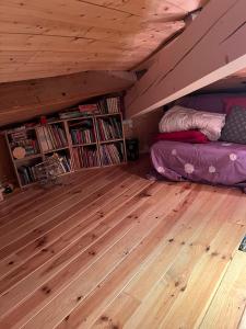 Beauregard-BaretMaison avec vue sur le Vercors的阁楼里有一间房间，里面有一张床和书架。