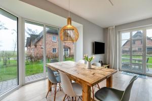 a dining room with a wooden table and chairs at Mynreet in Tating