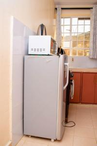 a microwave on top of a refrigerator in a kitchen at SJ Homes in Eldoret