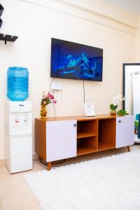 a living room with a tv on a wall at SJ Homes in Eldoret +16 photos