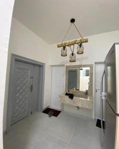 a white bathroom with a sink and a refrigerator at Hajir Garden House in Muşayna‘ah