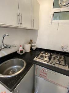a small kitchen with a sink and a stove at Hajir Garden House in Muşayna‘ah