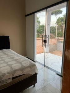 a bedroom with a bed and a sliding glass door at Lu Alter Residence in Santarém