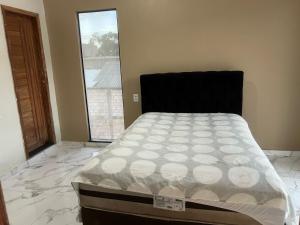 a bedroom with a bed in a room with a window at Lu Alter Residence in Santarém