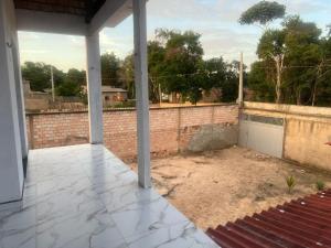a patio with a brick wall and a fence at Lu Alter Residence in Santarém
