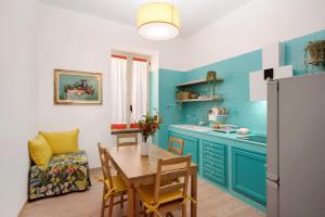 a kitchen with blue cabinets and a table with chairs at Ligea in Castellammare di Stabia