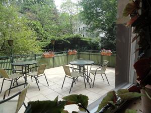 eine Terrasse mit Tischen, Stühlen und einem Zaun in der Unterkunft Hotel Graf Pückler in Berlin