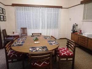 a dining room with a table and chairs and a television at Agape Gastehuis in Jagersfontein