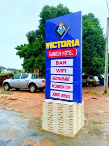 a sign for a car dealer in a parking lot at Victoria Garden Hotel & Fast Food Service in Onitsha