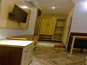 a room with a kitchen with a tv on the wall at Victoria Garden Hotel & Fast Food Service in Onitsha