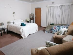a living room with a bed and a couch at Agape Gastehuis in Jagersfontein