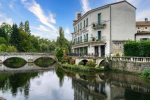 a building next to a river with a bridge at L’Ancien Séchoir de Brantôme in Puy-de-Fourches