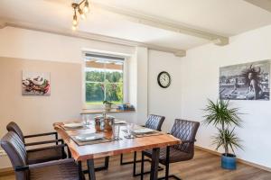 Un comedor con mesa y sillas de madera. en Ferienwohnungen Mayerhofer, en Arnstorf