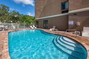 a large swimming pool with stairs in a building at Comfort Suites Fort Pierce I-95 in Fort Pierce