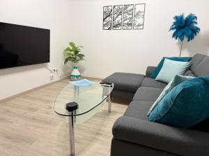 a living room with a couch and a glass table at Ferienwohnung mit Garten und Parkplatz mitten in Neumarkt in Neumarkt in der Oberpfalz