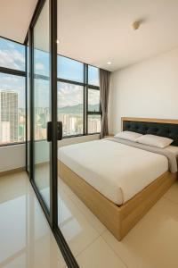 a bedroom with a large bed and large windows at Sunrise Sea View Apartment in Nha Trang +73 photos