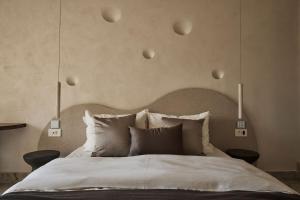 a bedroom with a large bed with white sheets and pillows at Uzenie All Suites Boutique Resort in Adelianos Kampos