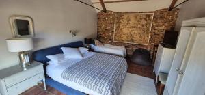 ein Schlafzimmer mit einem blauen Bett und einer Ziegelwand in der Unterkunft The Granary in Salford