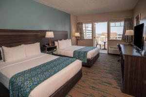 a hotel room with two beds and a flat screen tv at Gateway Hotel & Suites, an Ascend Collection Hotel in Ocean City