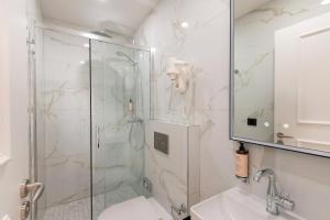 a bathroom with a shower and a toilet and a sink at Les Suites Tour Eiffel in Paris