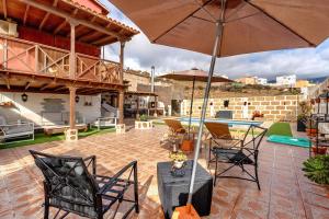 Un patio con sillas y una mesa con sombrilla. en Casa Elvira, en Chimiche