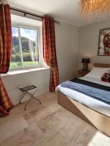 Saint-Martin-de-la-MerにあるLa maison du lacのベッドと窓のある寝室