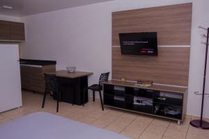 カイエンヌにあるAppartement Montabo Zen T2 - Jacuzzi - Jardin - Terasse - Wifi - Clim - Zac hibiscusのテーブルと壁にテレビが掛かっている部屋 +14枚の写真