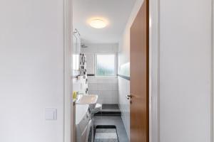 a white bathroom with a sink and a toilet at Bruchköbel 2 auch für Monteure in Bruchköbel +23 photos