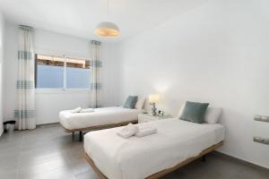 een slaapkamer met twee bedden en een raam bij Villa Aurora Playa La Arena in Puerto de Santiago +36 foto's